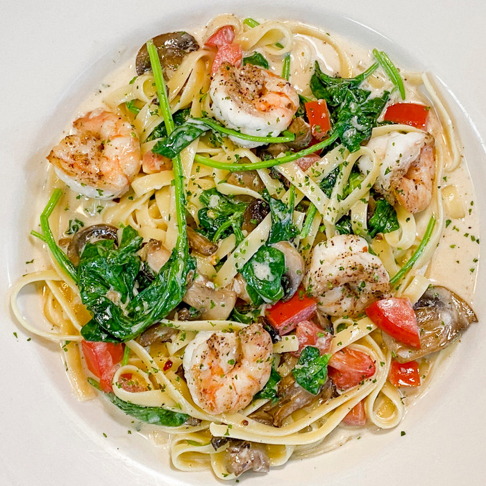 Pasta Nathan - Sautéed shrimp, mushrooms, diced tomatoes and spinach in a creamy lemon butter sauce served with fettuccine pasta.